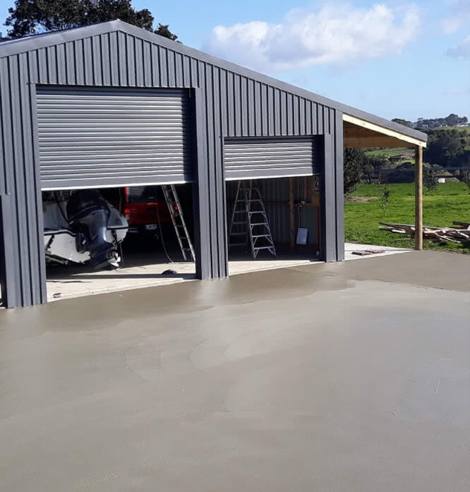 A three door garage with a new concrete driveway
